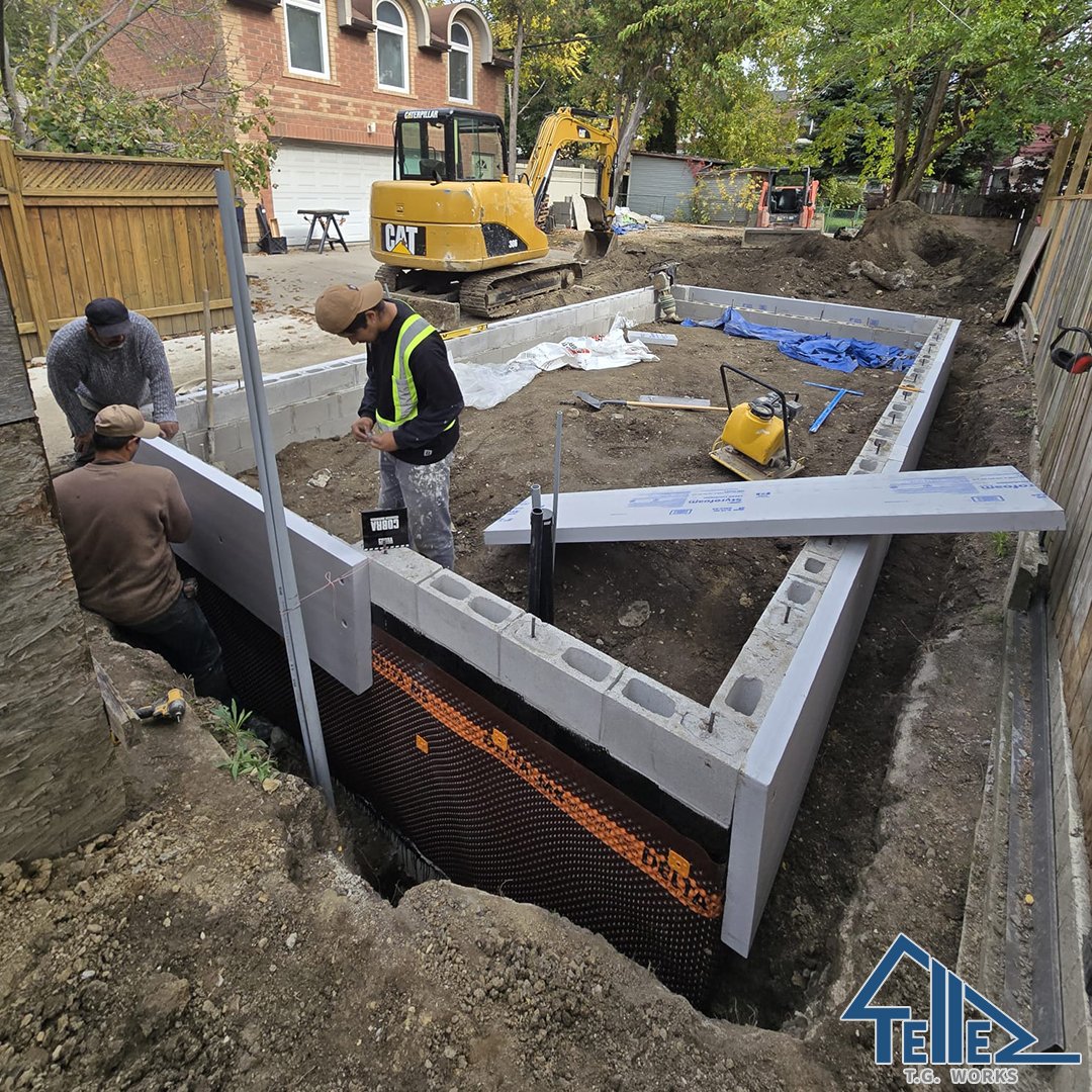 TG Works crew applying waterproofing and insulation to foundation walls in Toronto