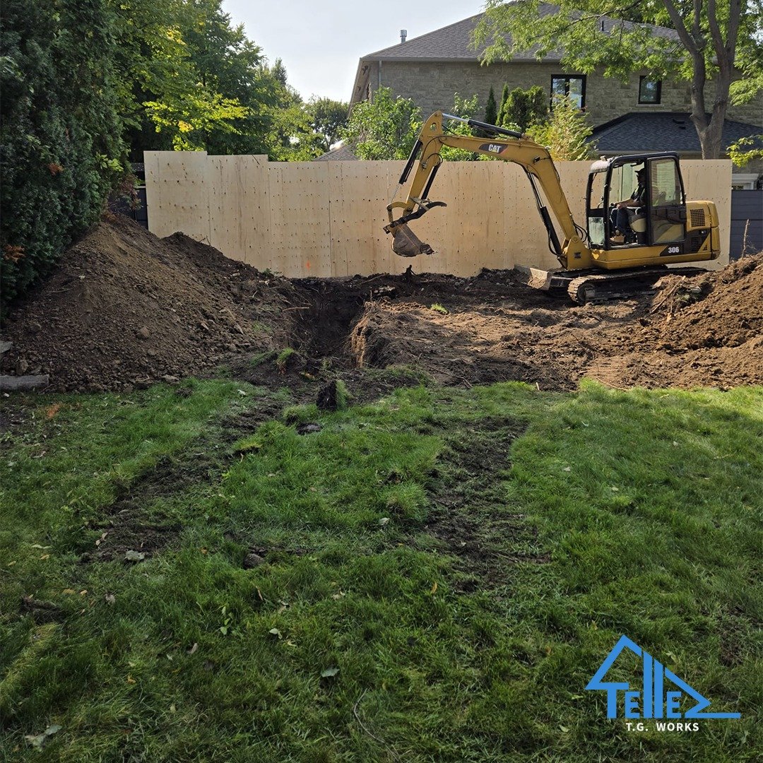 CAT excavator digging foundation for custom garage build in Toronto