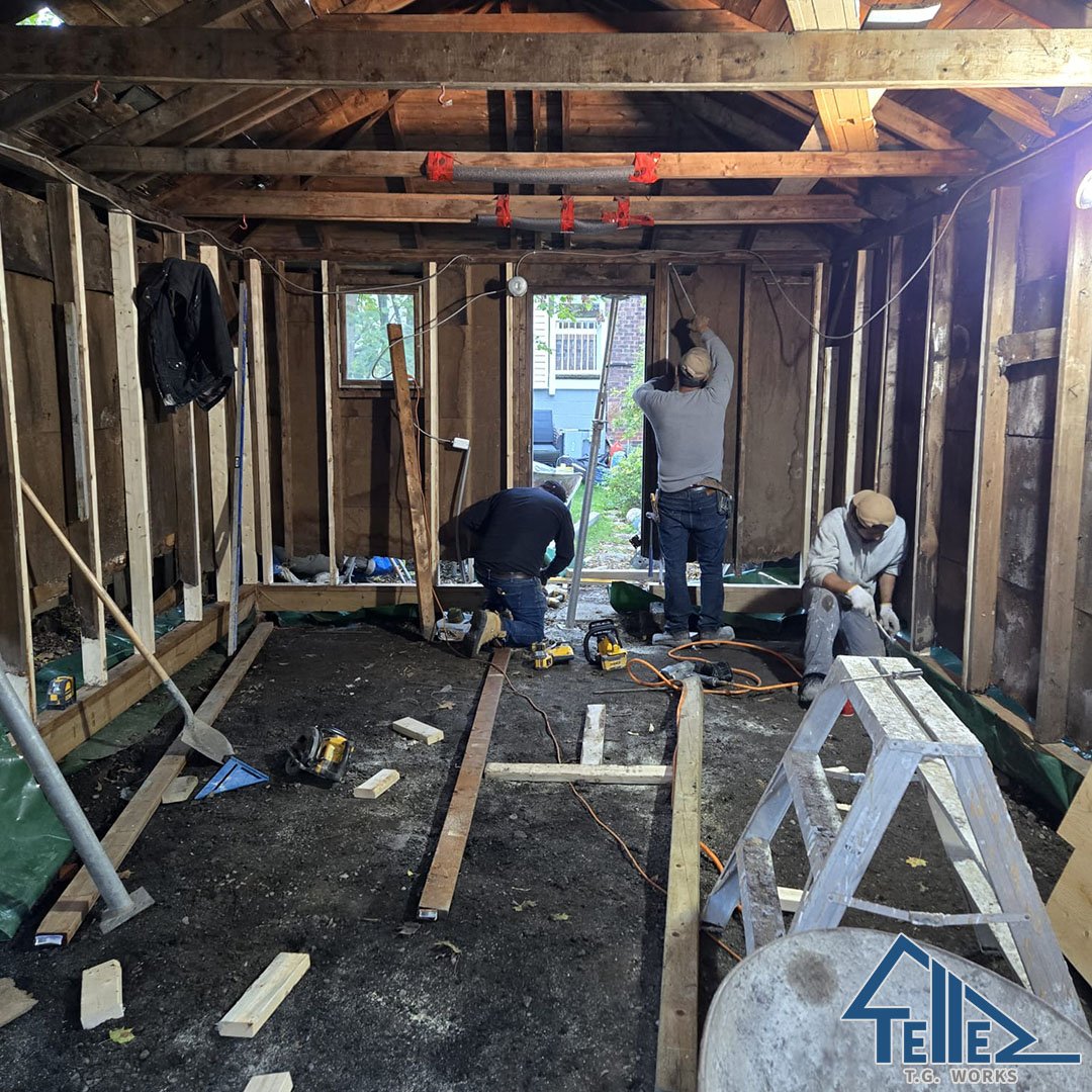 TG Works crew repairing structural framing inside garage in Toronto